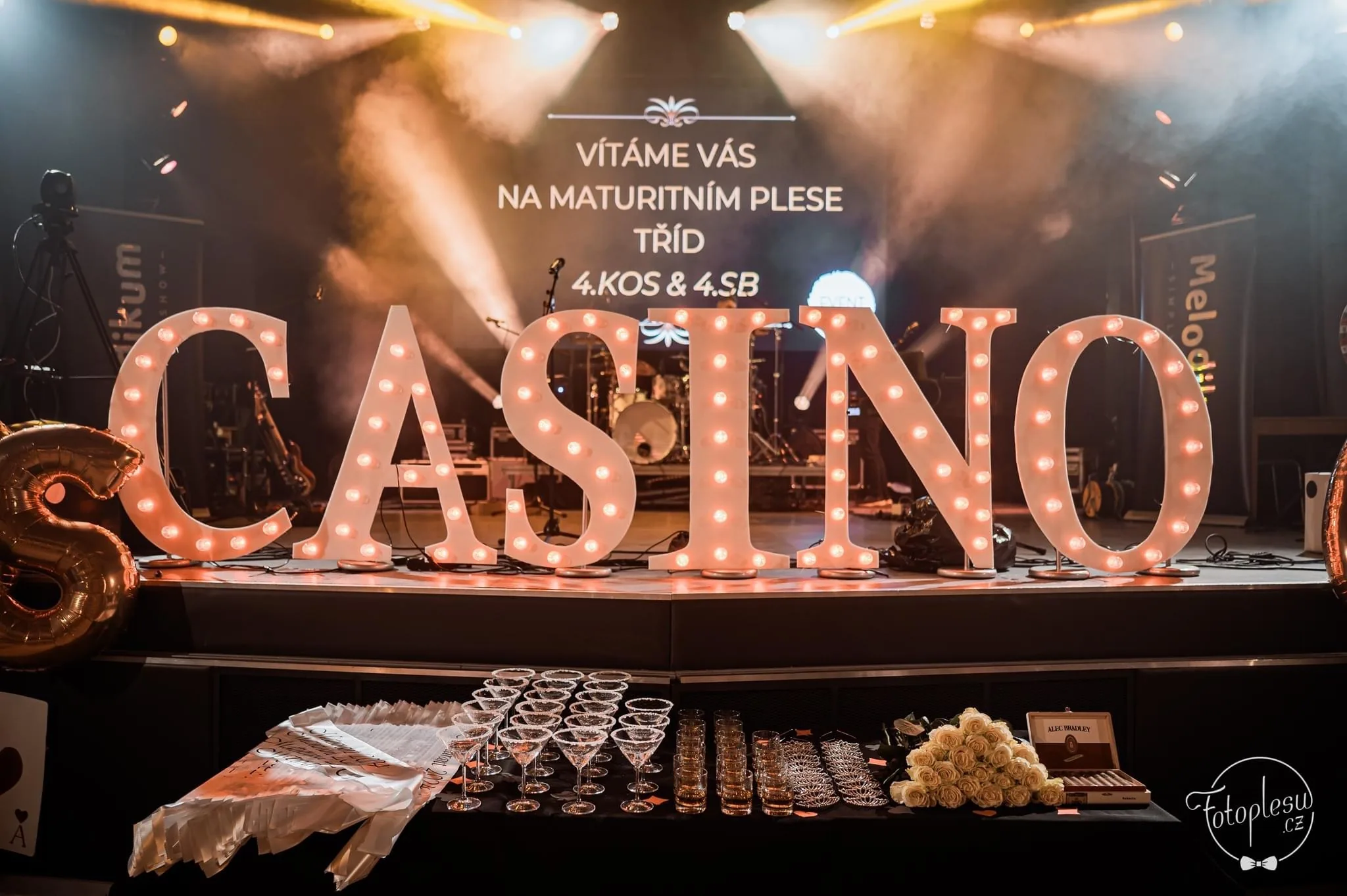 Světelný nápis a připravené pódium pro ples s tématem casino